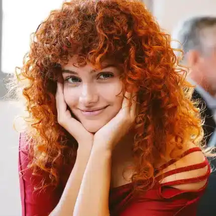 Cabello rizado rojo brillante y saludable, estilo natural y hermoso para destacar en cualquier ocasión.